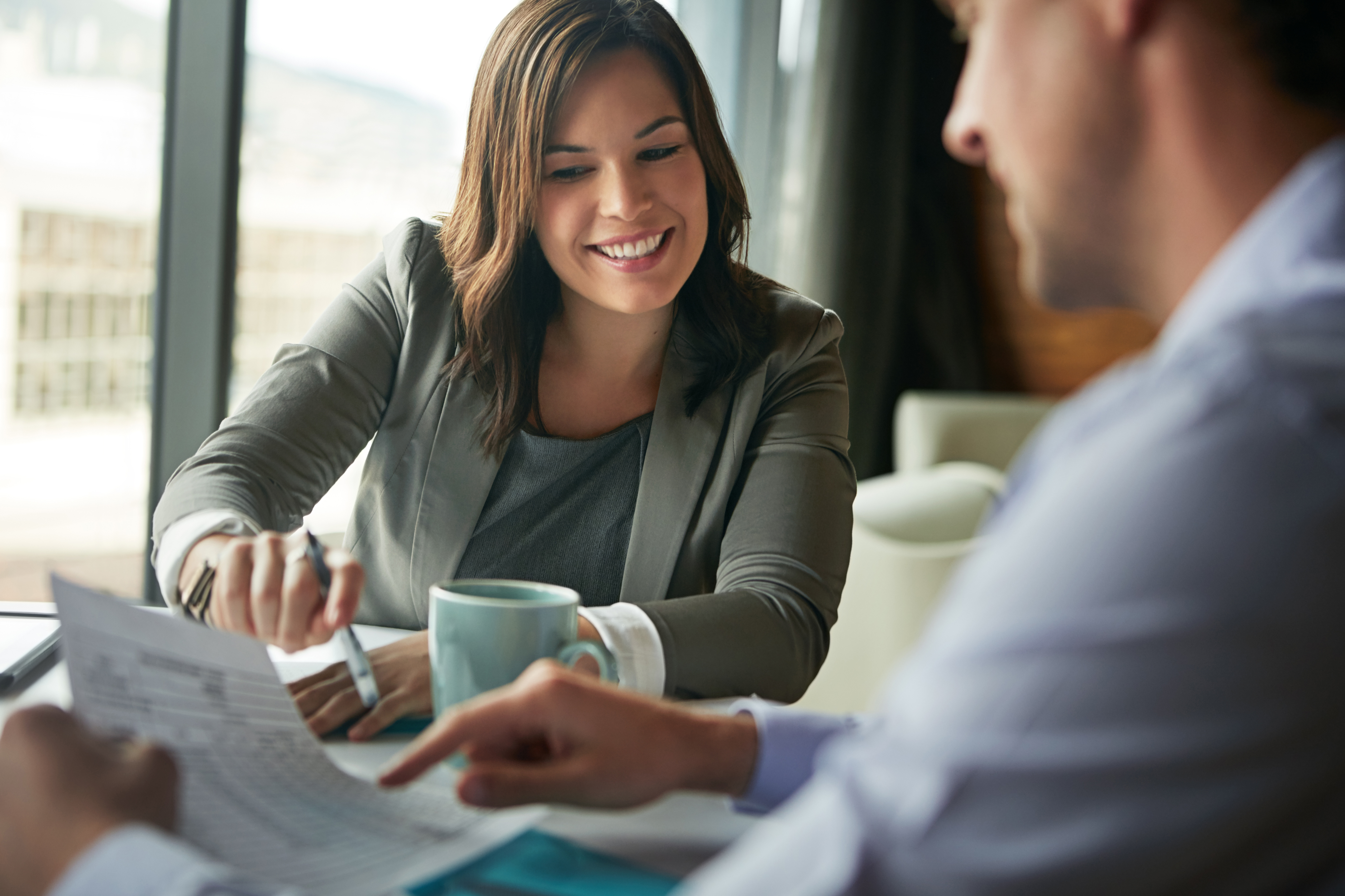 Photo of a woman sharing information and paperwork with a man.