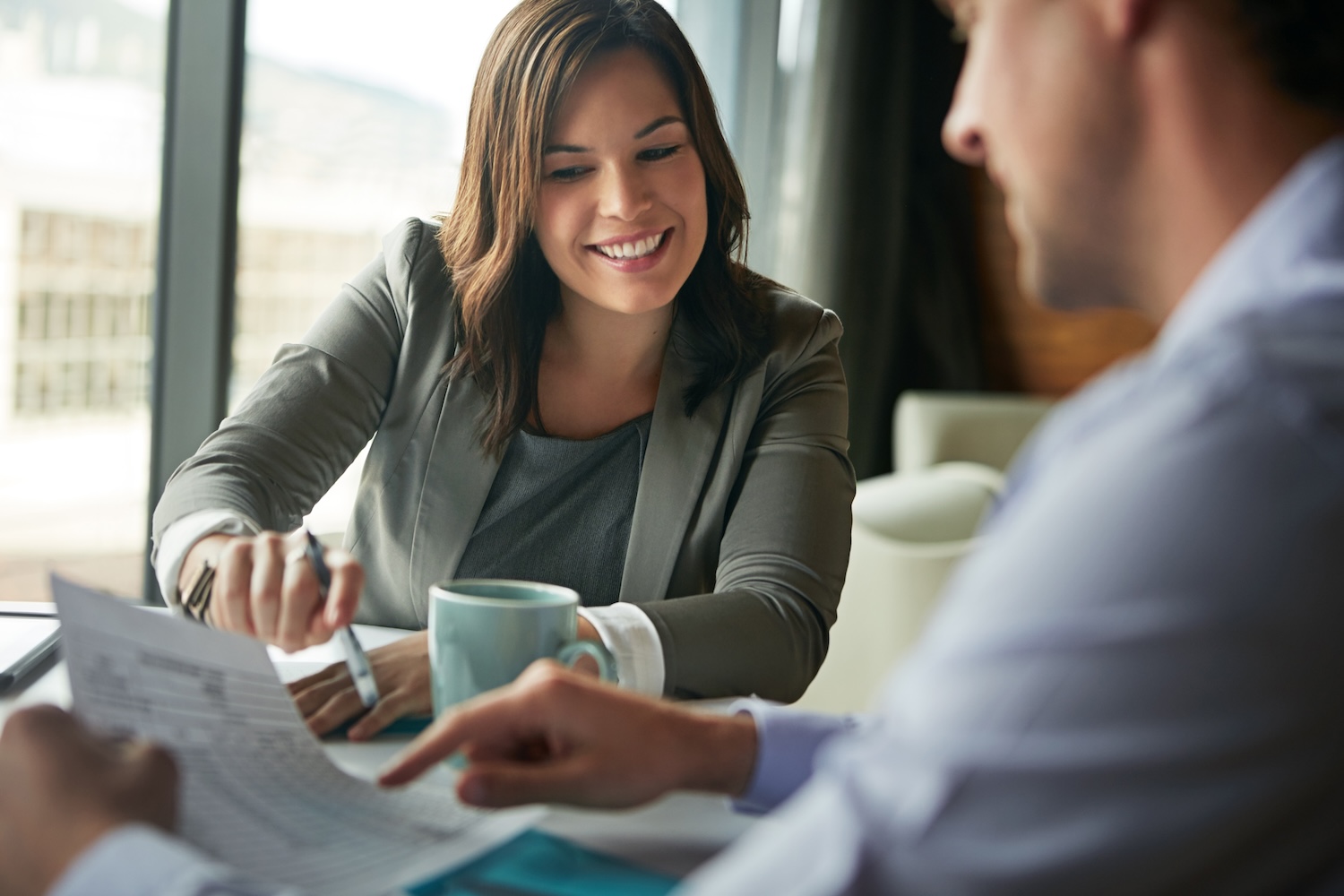 Office meeting with a man and woman near a window.
